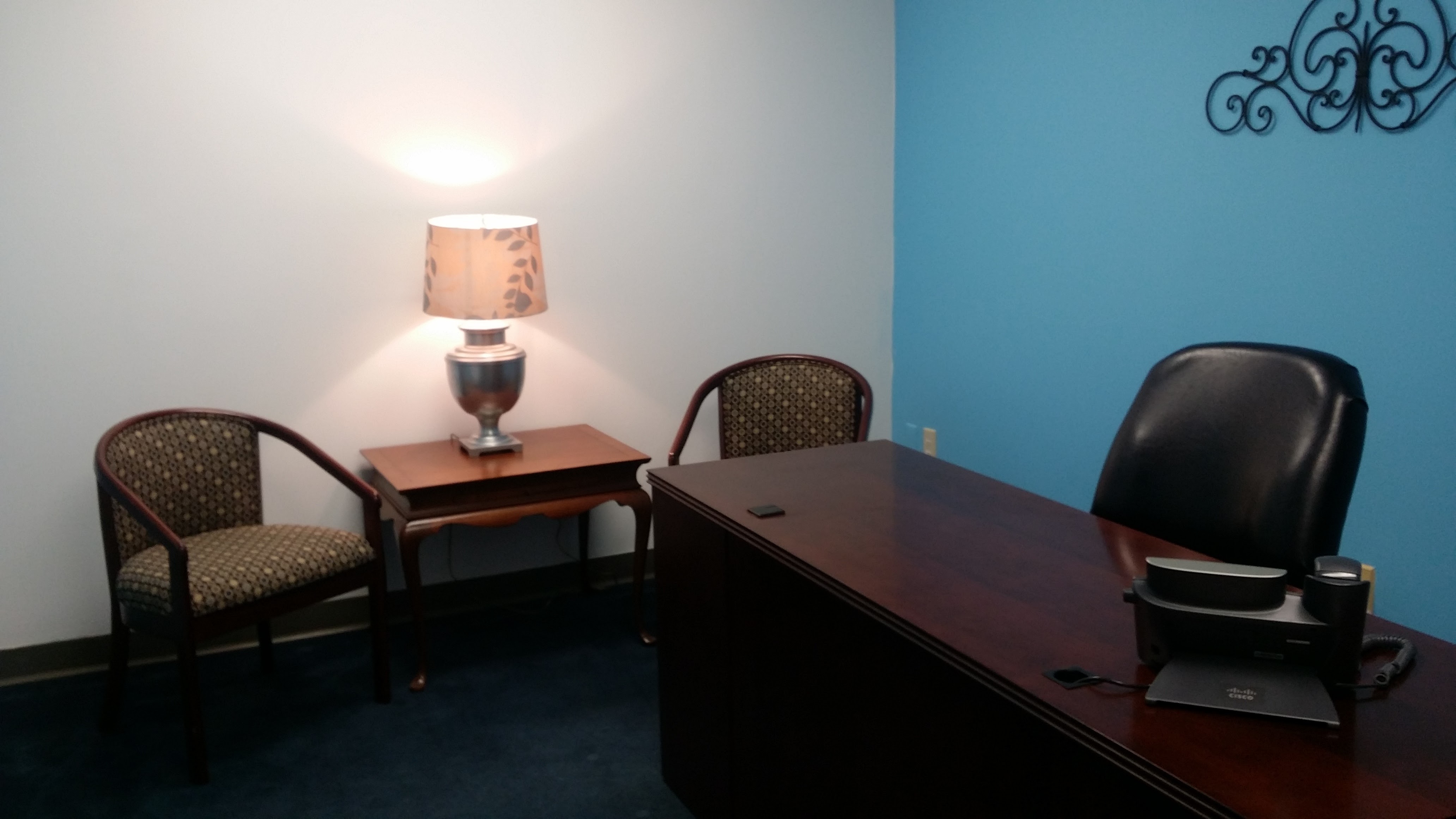 office space with blue wall, desk and table with two chairs
